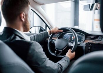 Hombre en traje conduciendo coche
