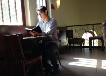 Chico leyendo en cafeteria