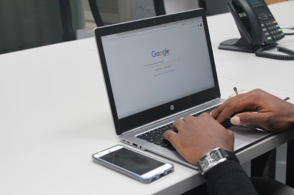 Manos sobre portatil con google abierto