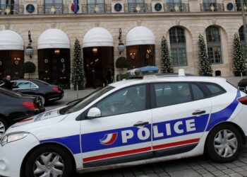 FILE - In this April 15, 2020 file photo a police car drives past the Ritz hotel in Paris. One of France's biggest unsolved criminal cases appears to have been cracked. Prosecutors announced that DNA from a 59-year-old former gendarme who killed hims