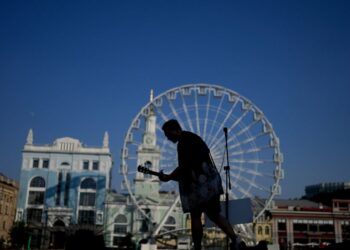 A street musician performs in Kyiv, Ukraine, Friday, June 10, 2022. With war raging on fronts to the east and south, the summer of 2022 is proving bitter for the Ukrainian capital, Kyiv. The sun shines but sadness and grim determination reign. (AP Ph