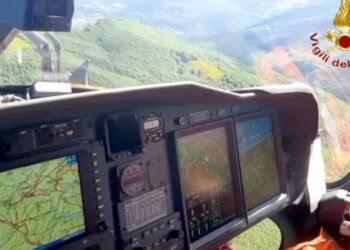 A Italian firefighter helicopter searches the site of a helicopter crash in central Italy, Saturday, June 11, 2022. Italian rescuers say they have located the scorched crash site of a helicopter carrying seven people that went down in north-central I