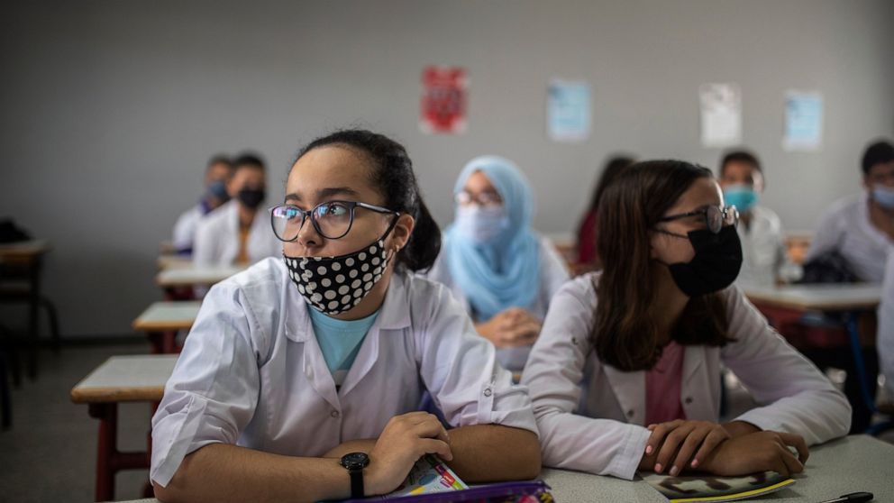 Students wear robes and face masks as they attend first day of new school year in Rabat, Morocco, Friday, Oct. 1 2021. Morocco delayed the return of schools until first of October to vaccinate 12-17 year old children against covid-19. (AP Photo/Mosa'