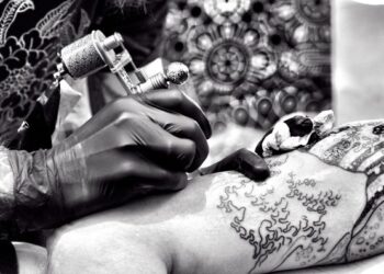 Persona tatuando brazo