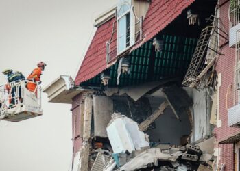 A fireman looks into the partially collapsed section of a building in China's Tianjin Municipality Tuesday, July 19, 2022. A gas explosion left some missing and others injured. (Chinatopix Via AP) CHINA OUT