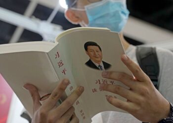 A man reads the books "Xi Jinping: The Governance of China" at a booth during the annual book fair in Hong Kong, Wednesday, July 20, 2022. The Hong Kong Book Fair will be held on July 20-26. (AP Photo/Kin Cheung)