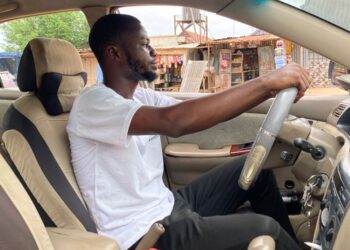 Adenekan Ayomide, 27, an undergraduate student turned a taxi driver following nationwide university strike, poses for a photograph inside his taxi in Abuja, Nigeria, Tuesday, May 10, 2022. “Nobody is talking about school again,” said Ayomide, who sai
