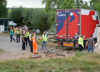 In this frame grab taken from video, policemen and rescuers stand at the site where a truck plowed into a gathering in the village of Nieuw-Beijerland, Netherlands, Saturday Aug. 27, 2022. A truck drove off a dike and slammed into a community barbecu