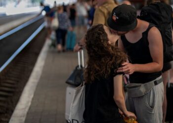 Davyd kisses his girlfriend Olha, after meeting again following a wartime separation of more than three months, at the train station in Lviv, Ukraine, Saturday, Aug. 27, 2022. (AP Photo/Emilio Morenatti)