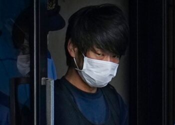 FILE - Tetsuya Yamagami, the alleged assassin of former Japanese Prime Minister Shinzo Abe, gets out of a police station in Nara, western Japan, on July 10, 2022, on his way to local prosecutors' office. A glimpse of Yamagami's painful childhood has