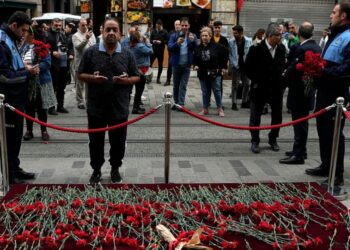 A man mourns in front of a memorial placed on the spot of Sunday's explosion on Istanbul's popular pedestrian Istiklal Avenue in Istanbul, Monday, Nov. 14, 2022. Police have arrested a suspect who is believed to have planted the bomb that exploded on