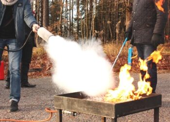 Personas probando extintor con fuego