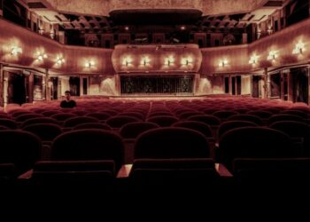 Teatro iluminado con butacas rojas elegante