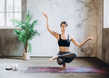 Mujer practicando yoga en casa sobre esterilla